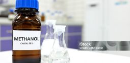 Selective focus of methanol brown amber glass bottle inside a laboratory. Blurred background with copy space.
