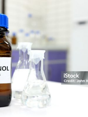 Selective focus of methanol brown amber glass bottle inside a laboratory. Blurred background with copy space.