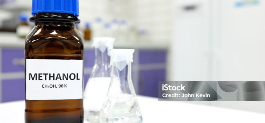Selective focus of methanol brown amber glass bottle inside a laboratory. Blurred background with copy space.